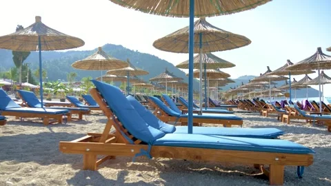 Seaside view with rows of lounge chairs and thatched umbrellas. Stock-Footage 332163179