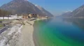 Off-season at hotel near beautiful lake in mountains, energy saving, aerial view 4k or 4k+ Resolution