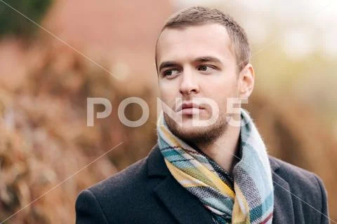Seasonal autumn fashion. Portrait of a handsome man wearing black coat, and a Stock Photos