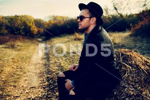 Seasonal autumn fashion. Portrait of a handsome man wearing black coat, a hat Stock Photos