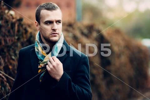 Seasonal autumn fashion. Portrait of a handsome man wearing black coat, and a Stock Photos
