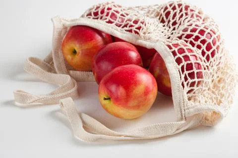 Seasonal red apples in a string bag on a white background in a eco-friendly bag Stock Photos