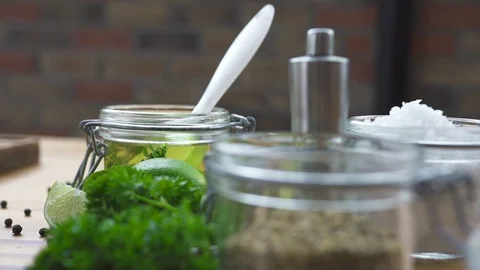 Seasoning composition. Black pepper, salt and olive oil on wooden table closeup Vidéo 104581153