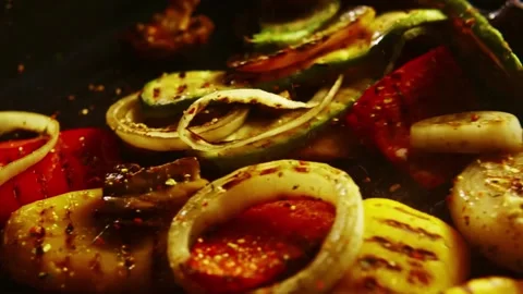 Seasoning falling on grilled vegetables in slow motion on black background. Stock Footage 346400480