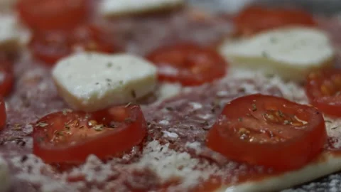 Seasoning pizza with basil on the baking tray. Preparing heart shaped pizza for Stock Footage 146660679