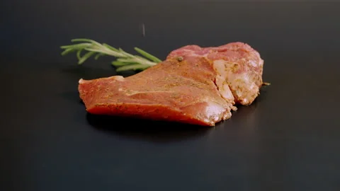 Seasoning a portion of raw meat with falling pepper Stock-Footage 162859136