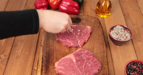 Seasoning two slices raw beef meat Stock Footage
