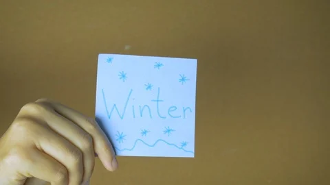 Seasons in motion. Hands passing each other sticky notes with letters funny Stock Footage 98858841