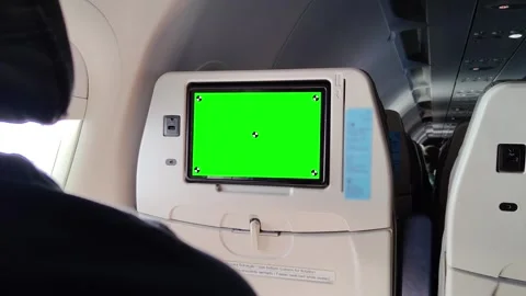 Seatback screen with green chroma key, USB port, and tray on airplane seat Stock Footage 311545681