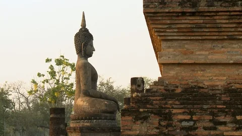 Seated Buddha image facing brick wall of temple Video stock 120005197