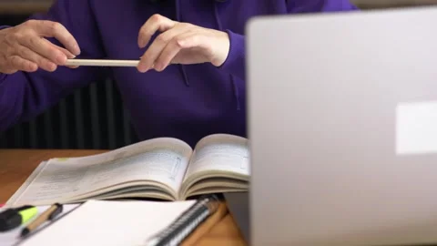 Seated at desk with laptop and study materials student taking photo of notes by Stock Footage 266902001