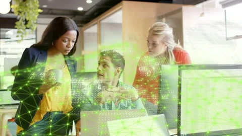 Seated dev starting tech demo on laptop, women leaning in, reviewing as green Stock Footage 333106055