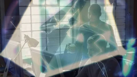 Seated dev using PC initiating tech hologram forming around while peer watching Stock Footage 333078614