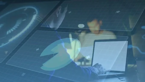 Seated developer typing on laptop as colleague leaning in, holo dials shifting Stock Footage 335282684