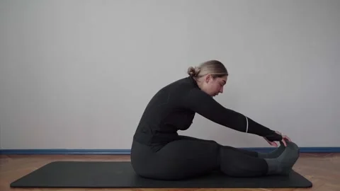 Seated Forward Fold Hamstring Stretch on Mat for Home Mobility Stock Footage 340545198