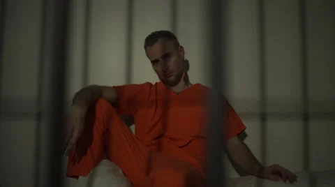 Seated inmate in prison stares down the camera Stock Footage 59763035
