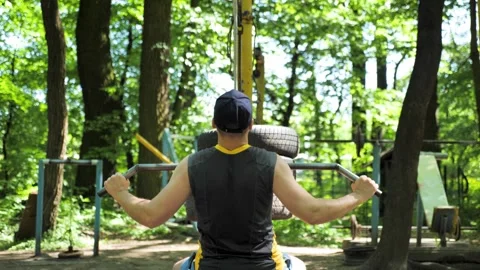 Seated lat pulldown exercise workout on outdoor gym Stock Footage 276094523
