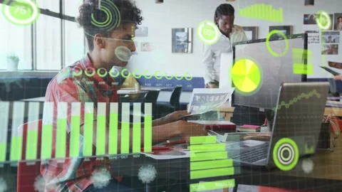 Seated man comparing printed report with laptop in open office, validating data Stock Footage 332543047