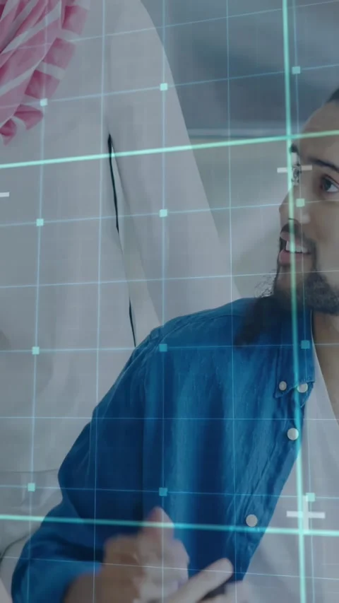 Seated man grabbing stylus after peer leaning in, explaining tech interface with Stock Footage 332335271