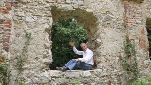Seated man greets Vídeos de archivo 7904893