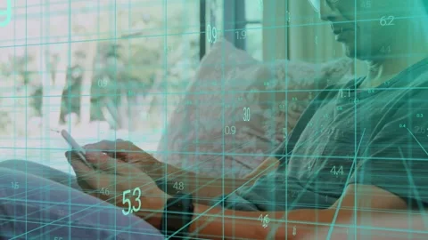 Seated man tapping, scrolling phone, camera revealing face as teal tech overlay Stock Footage 334202540