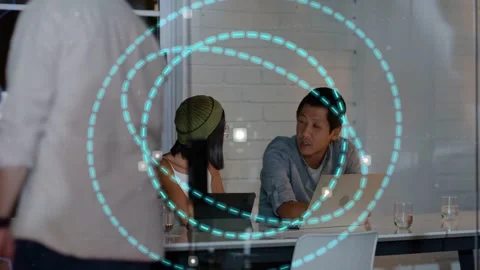 Seated pair sharing tablet as team joins, reviewing business data with teal Stock Footage 332956211