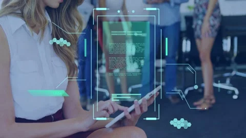 Seated woman tapping tablet in tech office, holographic UI animating over tablet Stock Footage 333631894