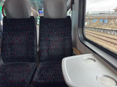 Seating Area Inside a Train With Empty Seats and a Small Table Next to a Wi.. Stock Photos