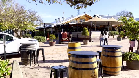 Seating around old wine barrels outside popular Peregrine Farm Stall in Grabouw Stock Footage 342320377