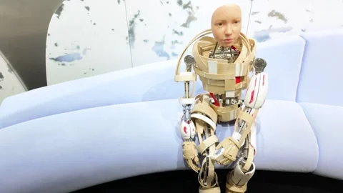 Seating down cyborg robot with Kid's face, Seoul, South Korea - 4K Tilt up Stock Footage 338043761