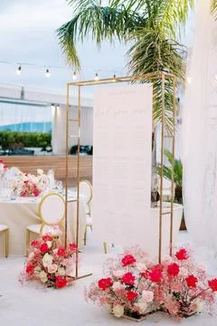 Seating plan hangs on a rectangular frame next to bouquets of flowers in front Foto stock