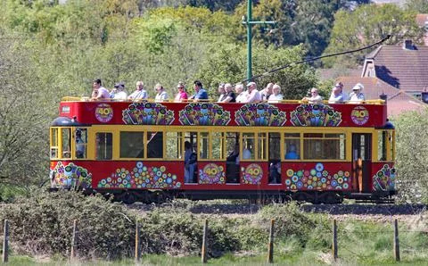 SEATON, DEVON, ENGLAND - MAY 22ND 2012: A decorated red tram travels along th Stock Photos