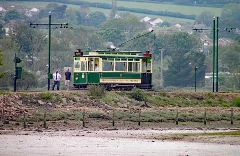 SEATON, DEVON, ENGLAND - MAY 22ND 2012: Two men get out of a green tram to in Stock Photos