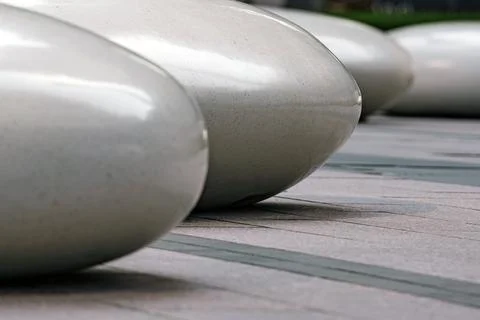 Seats in the shape of smooth large stones in a public park. Stock Photos