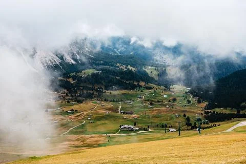Seceda mountain landscape with scattered chalets and misty clouds in the Do.. Stock Photos