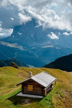 Seceda mountain peak shrouded in clouds above a rustic wooden hut in the Do.. Stock Photos