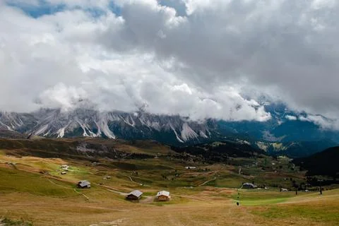 Seceda mountain range in the Dolomites with scattered chalets under dramati.. Stock Photos