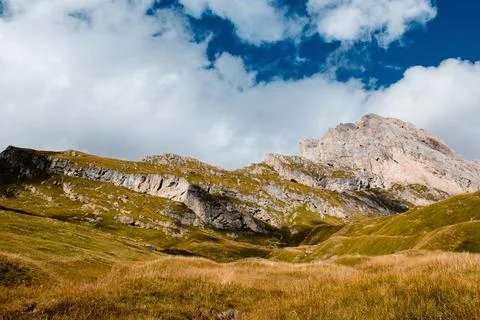 Seceda mountain range with green slopes and dramatic cloudy sky in Dolomites Stock Photos