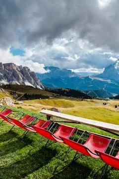 Seceda mountain range panorama with red chairs and dramatic clouds in the D.. Stock Photos