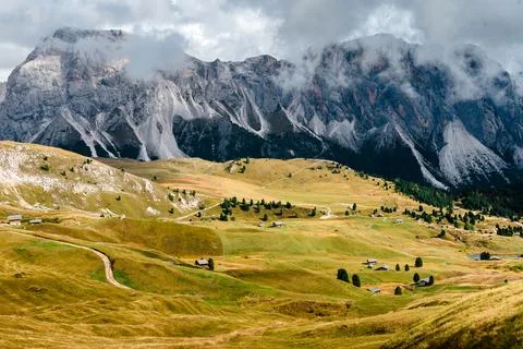 Seceda mountain range with rolling green hills and scattered chalets in the.. Stock Photos
