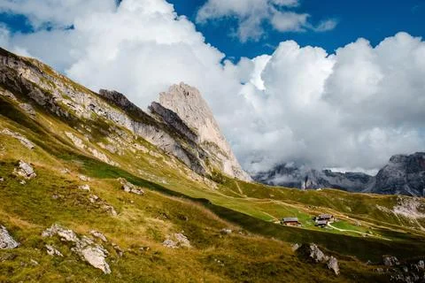 Seceda mountain range with traditional alpine huts under dramatic clouds in.. Stock Photos