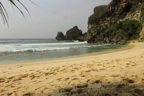 Secluded Beach with Cliffs and Calm Waves Stock Photos