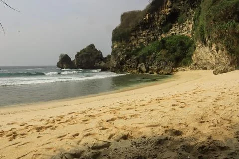 Secluded Beach with Cliffs and Calm Waves Stock Photos