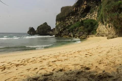 Secluded Beach with Cliffs and Calm Waves Stock Photos