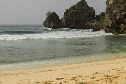 Secluded Beach with Cliffs and Calm Waves Stock Photos