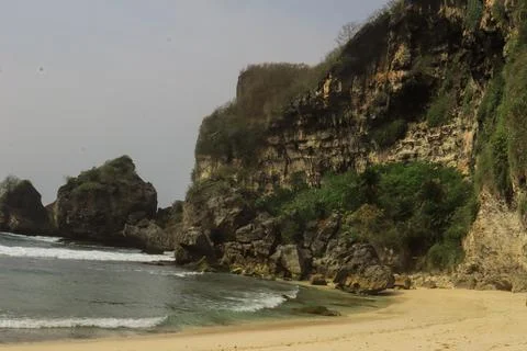 Secluded Beach with Cliffs and Calm Waves Stock Photos