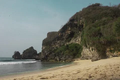Secluded Beach with Cliffs and Calm Waves Stock Photos
