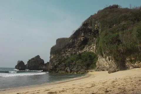 Secluded Beach with Cliffs and Calm Waves Stock Photos