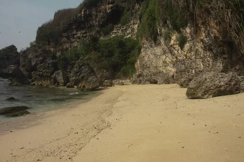 "Secluded Beach with Cliffs and Calm Waves" Stock Photos
