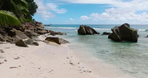 Secluded beach with large granite rocks and calm waves. La Digue, Seychelles. Stock Footage 345382132
